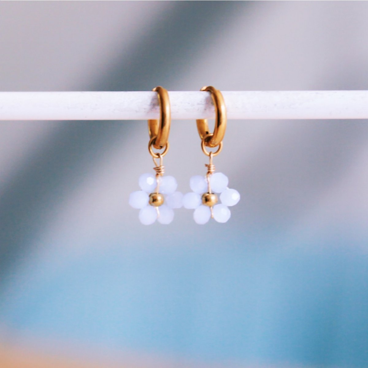 Stainless steel hoop earrings with faceted daisy flower - light blue