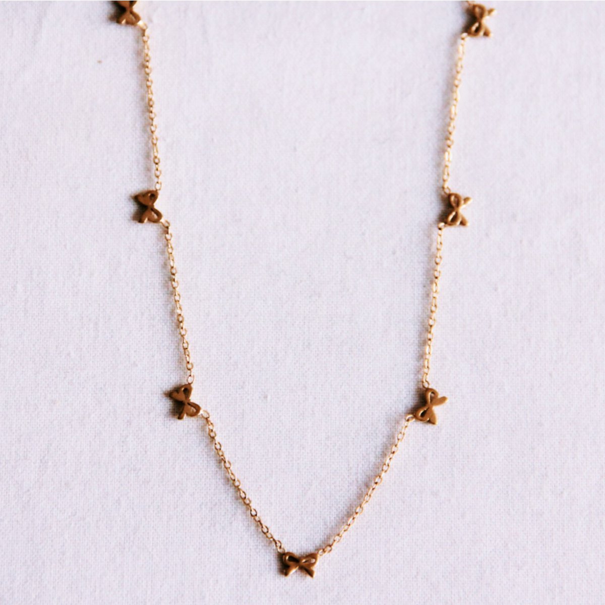 Delicate necklace with bows - gold