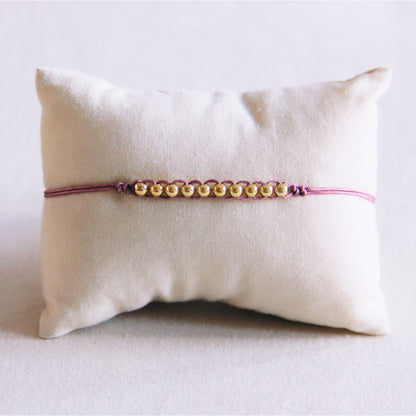 Satin bracelet with gold-colored beads - lilac