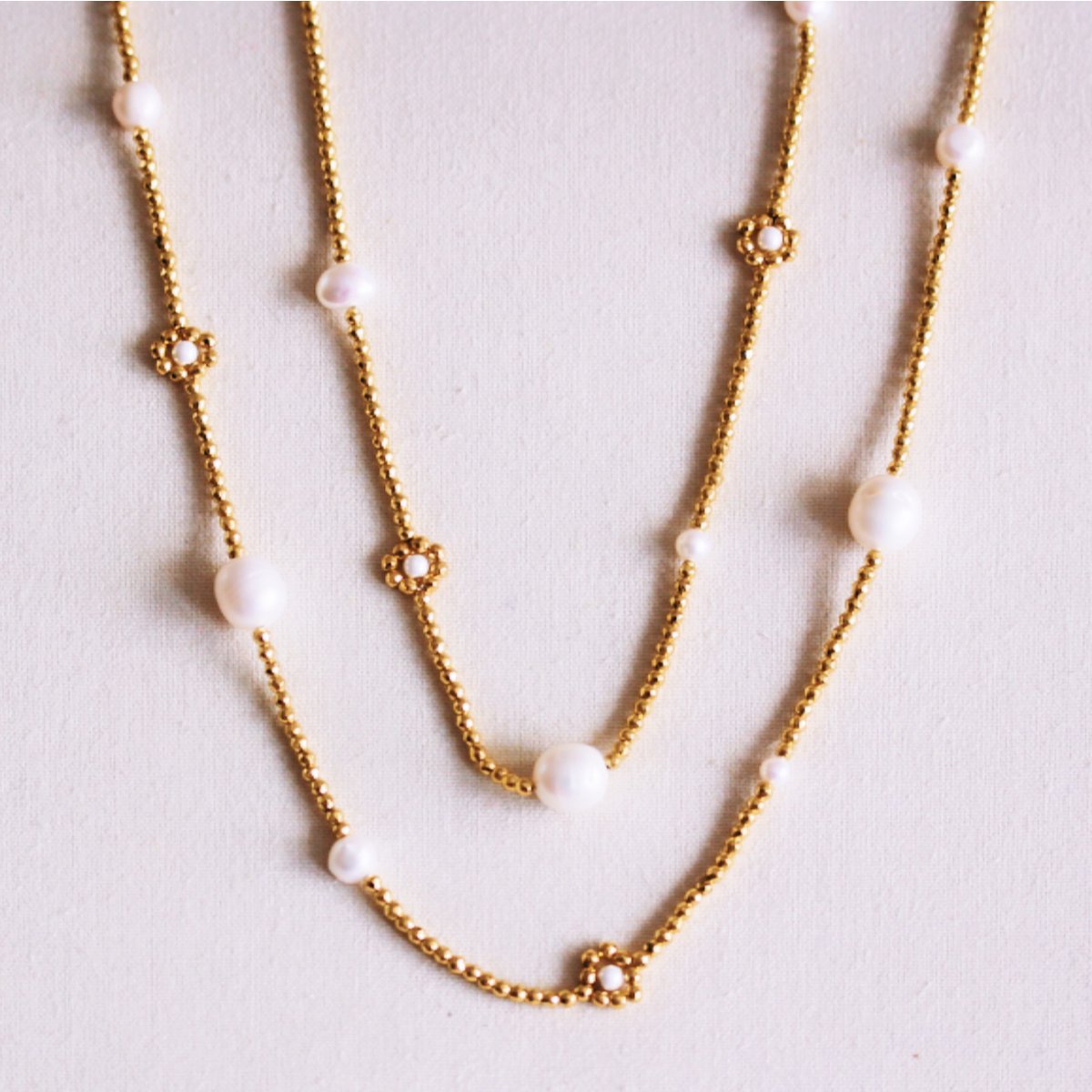 Long beaded necklace with pearls and daisy flowers