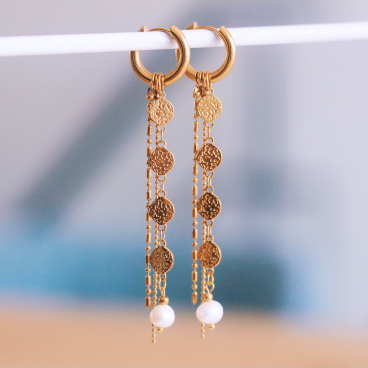 Stainless steel hoop earring with coins, pearl, and strings