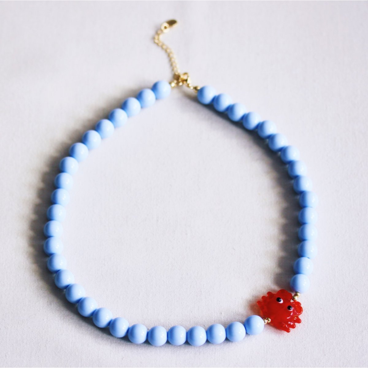 Beaded necklace with crab - light blue