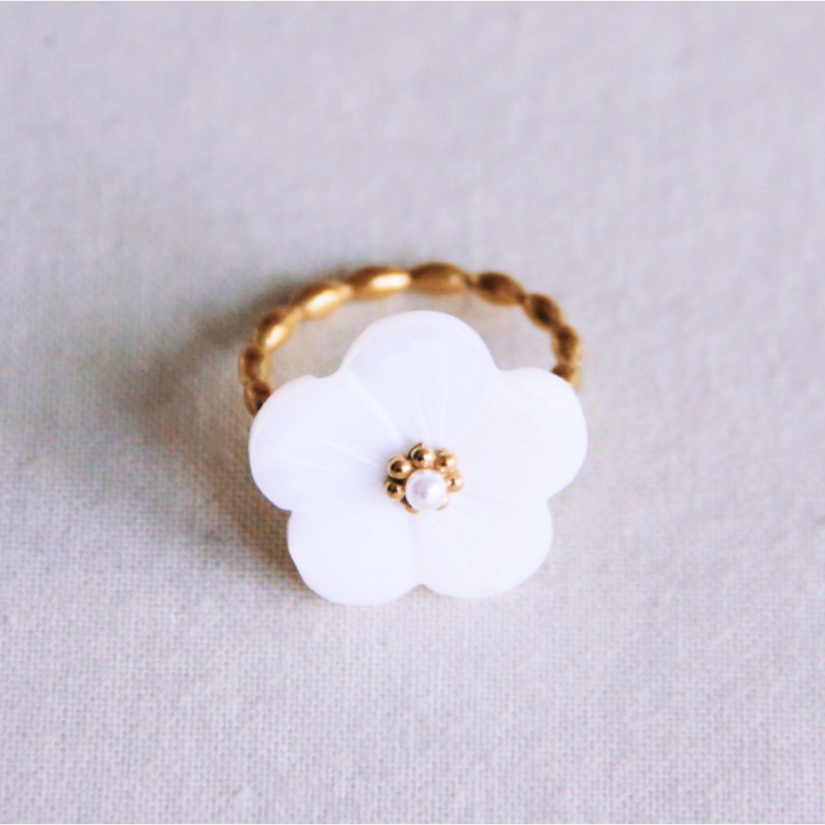 Stainless steel twisted ring with white flower and mini pearl