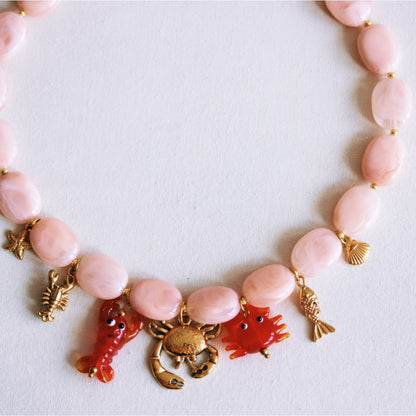 Oval beaded necklace with "Crabby's" charms