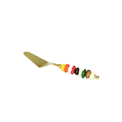Golden pie server with multi-colored stone handle