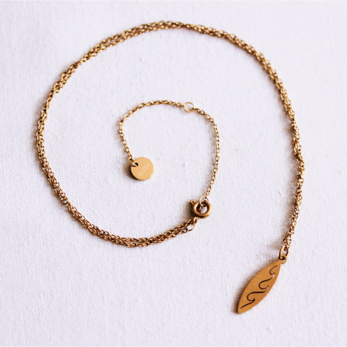 Delicate necklace with surfboard