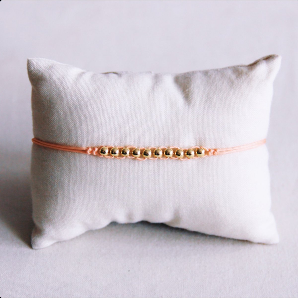 Satin bracelet with gold-colored beads - peach