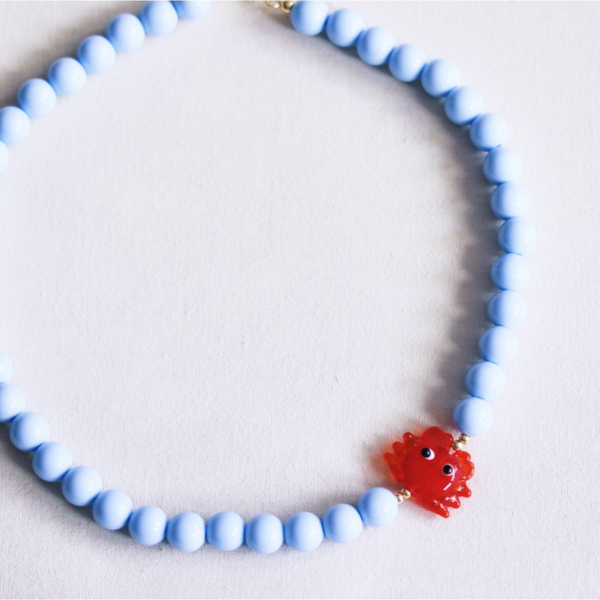 Beaded necklace with crab - light blue