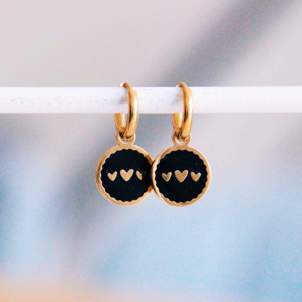 Stainless steel hoop earrings with round charm 3 hearts - black/gold
