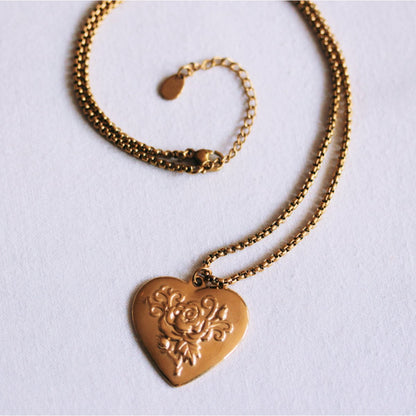 Box chain necklace with an ornate heart