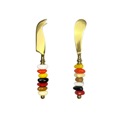 Golden cheese service with multi-colored stone handles