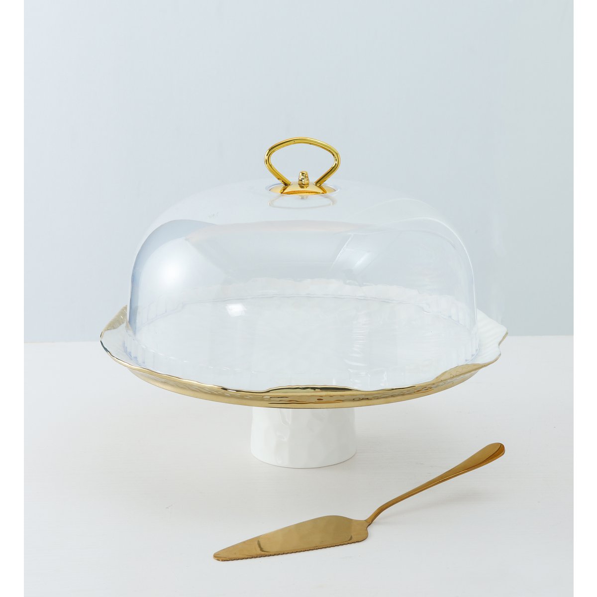 White porcelain cake bell with gold edges with pie shovel