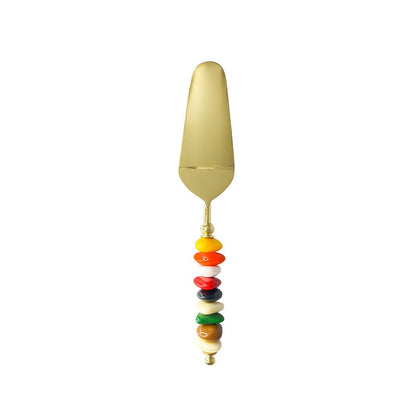 Golden pie server with multi-colored stone handle
